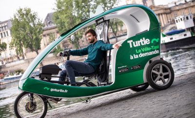 vélo taxi vert de la société Turtle avec chauffeur pour des course sur commande