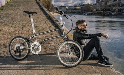 Vello Bike Bike+ Gears en premier plan avec homme assis sur un ponton en arrière plan