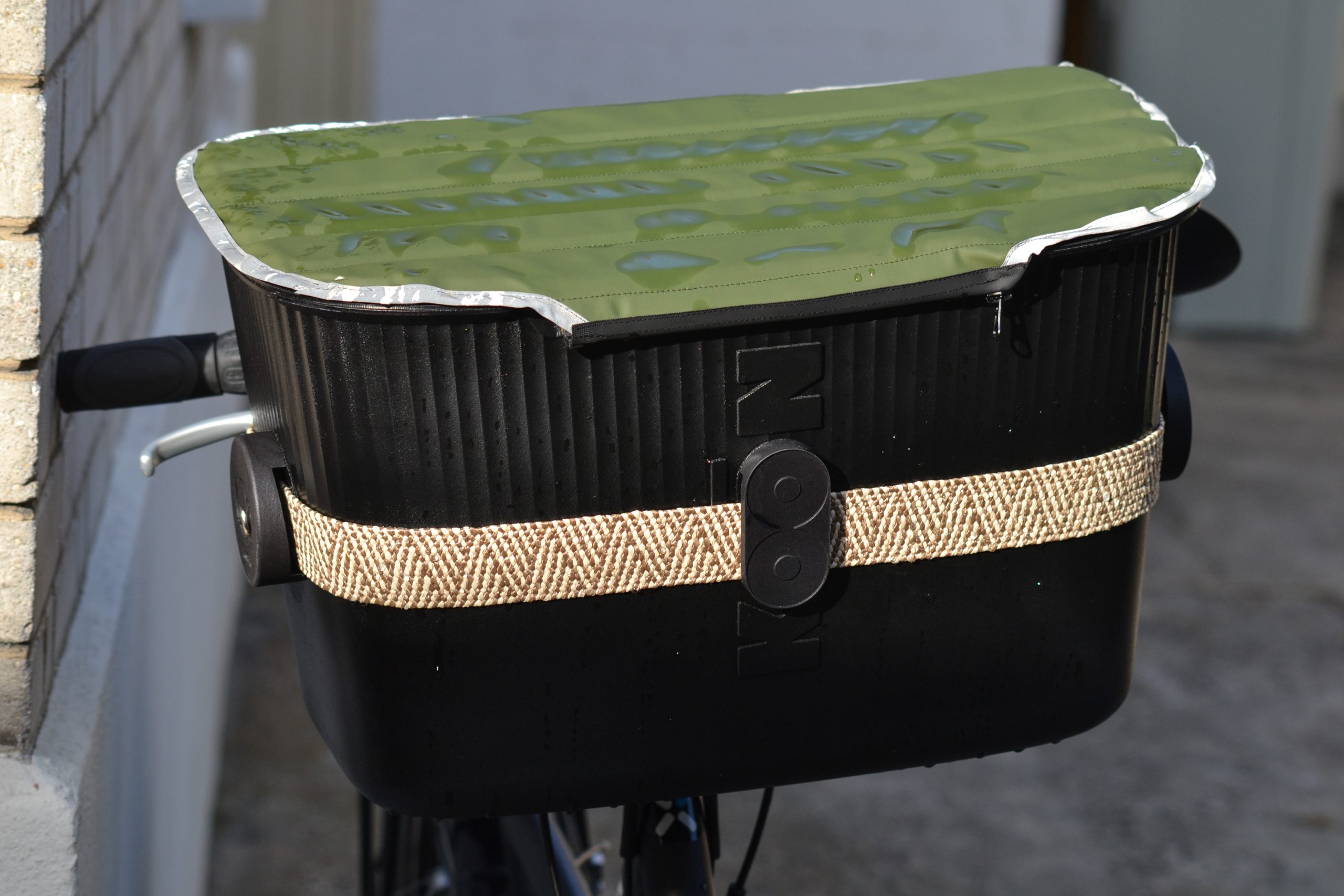 Panier Koon ride de couleur noir avec couvercle vert installé sur le guidon d'un vélo