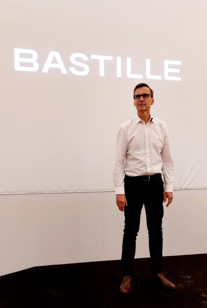 GILLES Henry créateur du vélo Bastille debout devant un écran où apparaît le nom Bastille