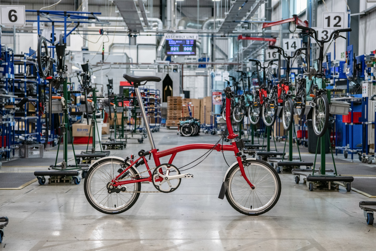 Vélo Brompton de couleur rouge posé de profil au coeur de l'atelier de montage