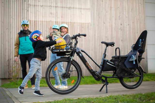 vélo cargo O2feel Equo 7 ABS de profil avec une famille autour